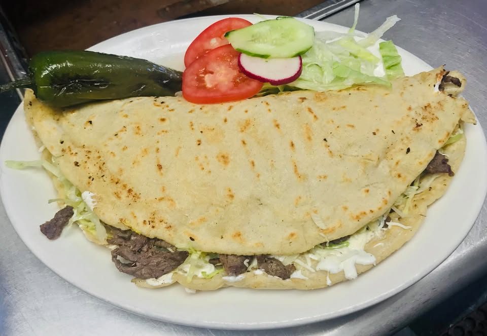 A quesadilla with carne asada, salad and a grilled chilli on the plate at La Esquina Mexicana